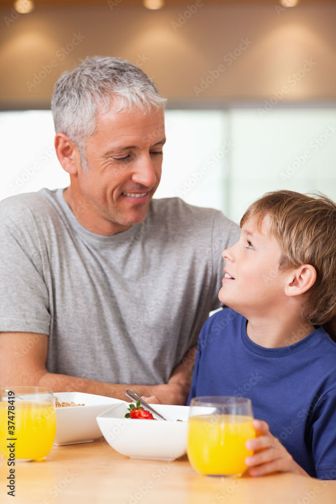 Portrait of a young boy and his father having breakfast