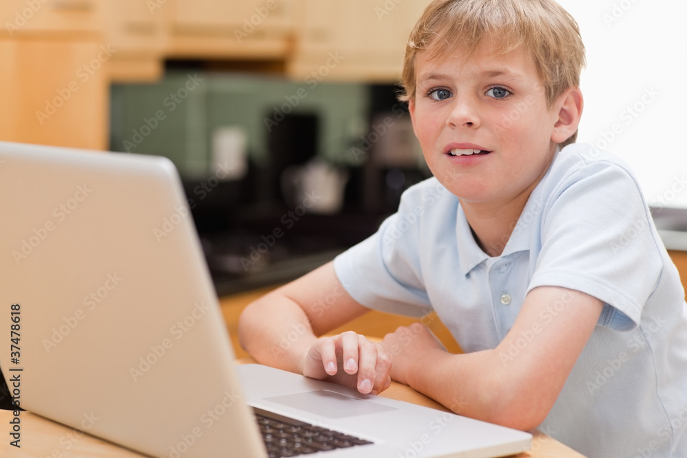 Lovely boy using a notebook Lovely boy using a notebook