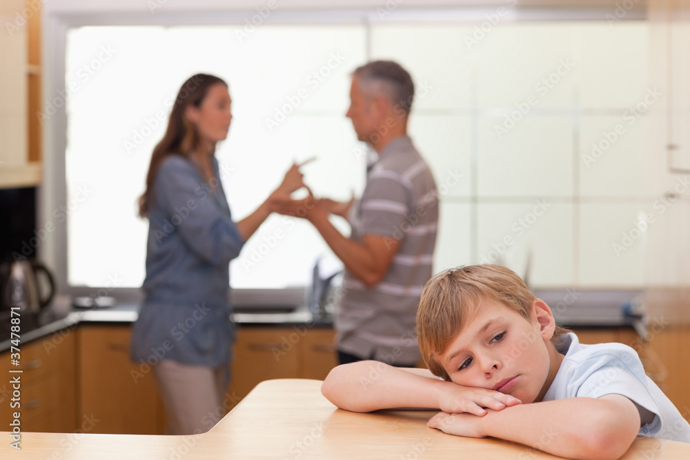 Fototapeta premium Sad little boy hearing his parents arguing
