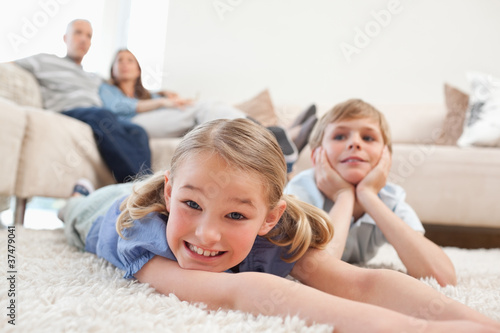 Siblings lying on a carpet