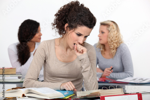 Fotografie A young university student reviewing her textbooks before class