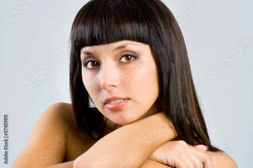 pretty woman with long straight black hair looking at camera