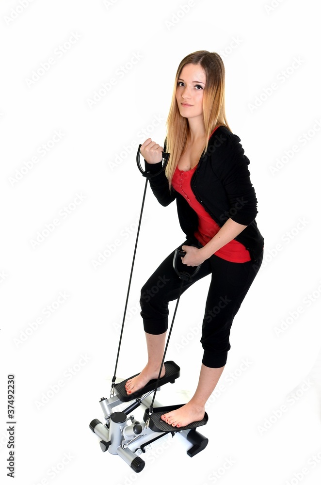 young woman exercising on stepper trainer, vertical young woman exercising on stepper trainer, vertical