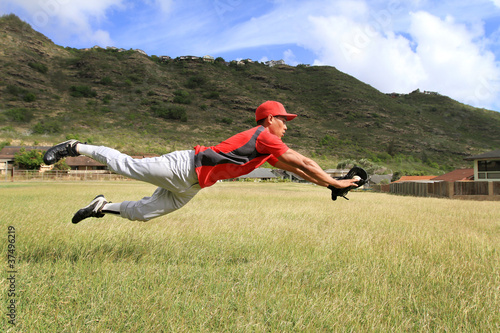 Baseball player dives to catch the ball