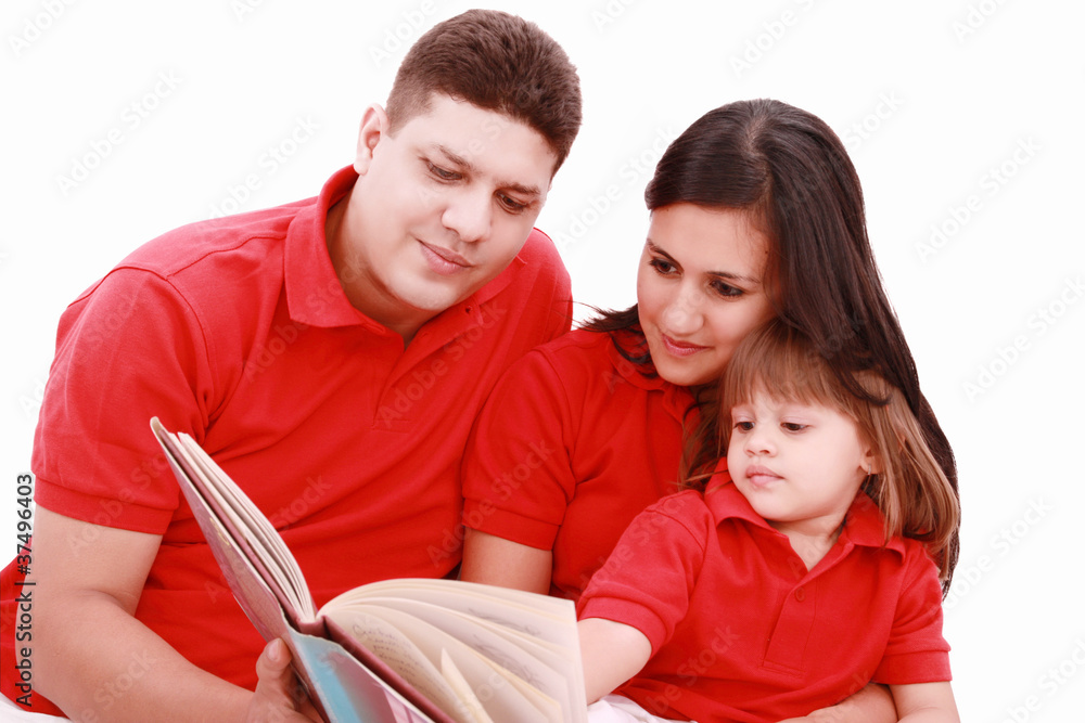 Family sitting on floor reading book at home Family sitting on floor reading book at home