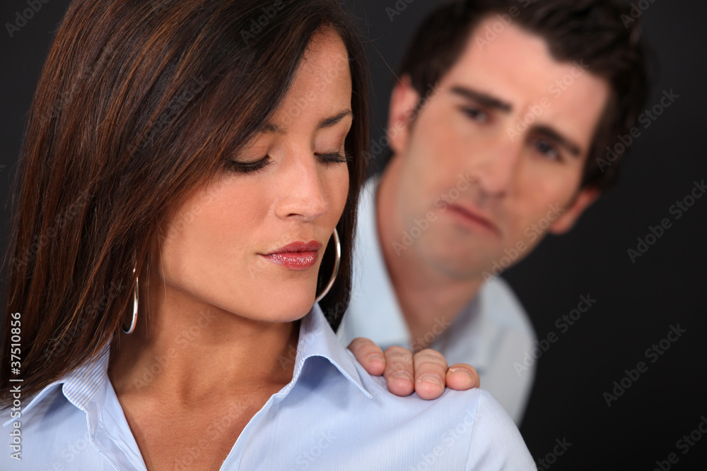 Concerned man touching his wife's shoulder Concerned man touching his wife's shoulder