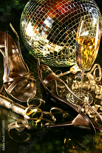 Silver party shoes on floor with champagne glass