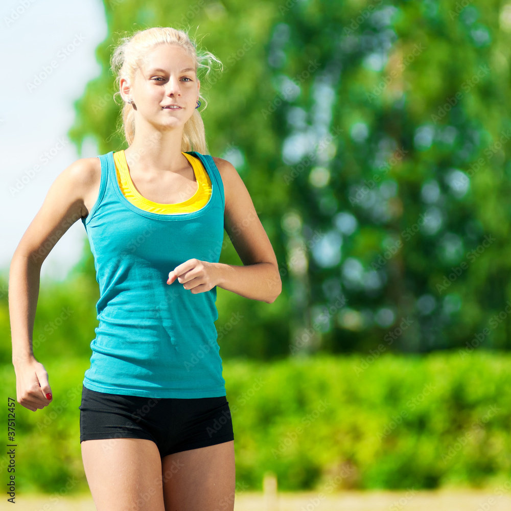 Young woman running in green park Young woman running in green park