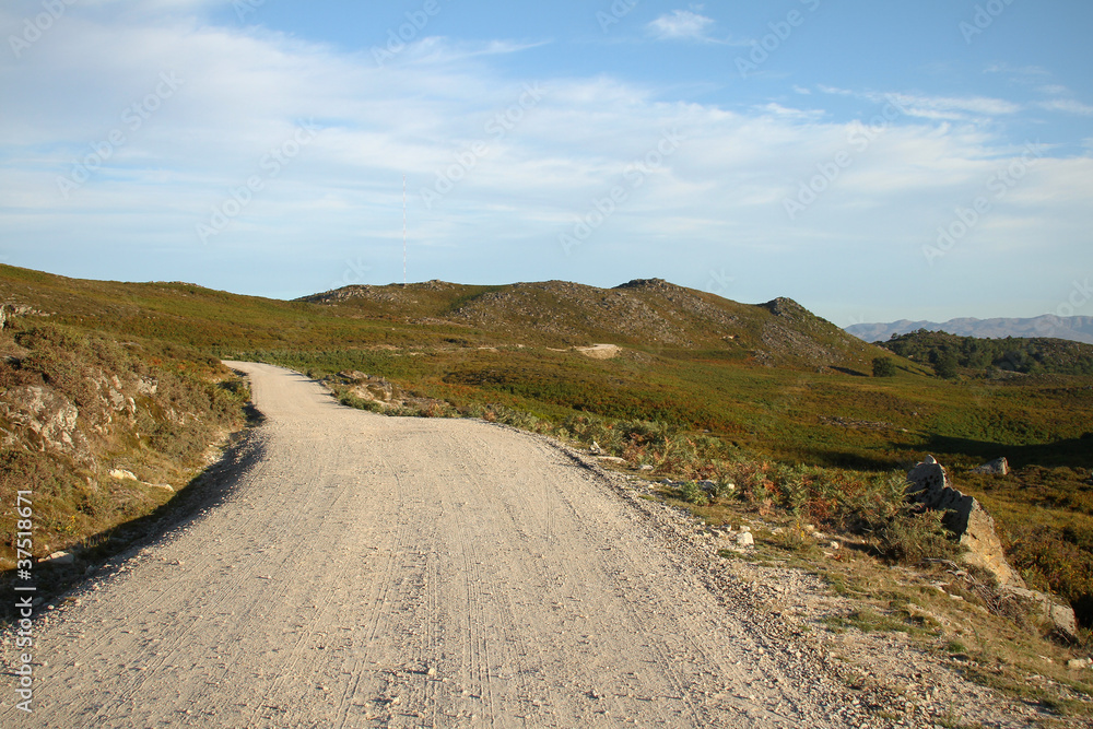 Gravel road through the grassy foothills in northern Portugal