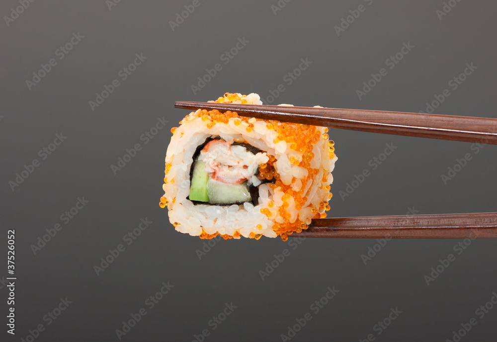 Sushi with chopsticks isolated over gray background Sushi with chopsticks isolated over gray background