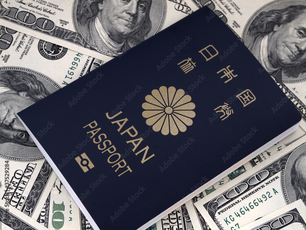 A Japanese passport with 100 dollar note background A Japanese passport with 100 dollar note background