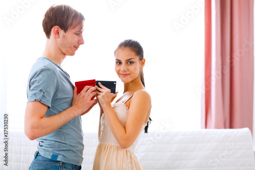 Young couple exchanging gifts