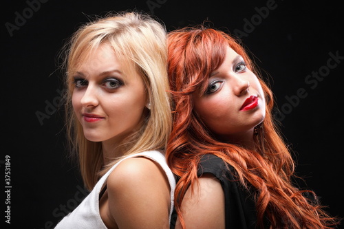 two happy young girlfriends black background