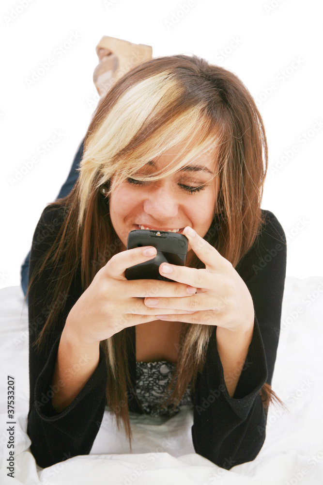 Teenage girl chatting with cell phone lying down - isolate Teenage girl chatting with cell phone lying down - isolate