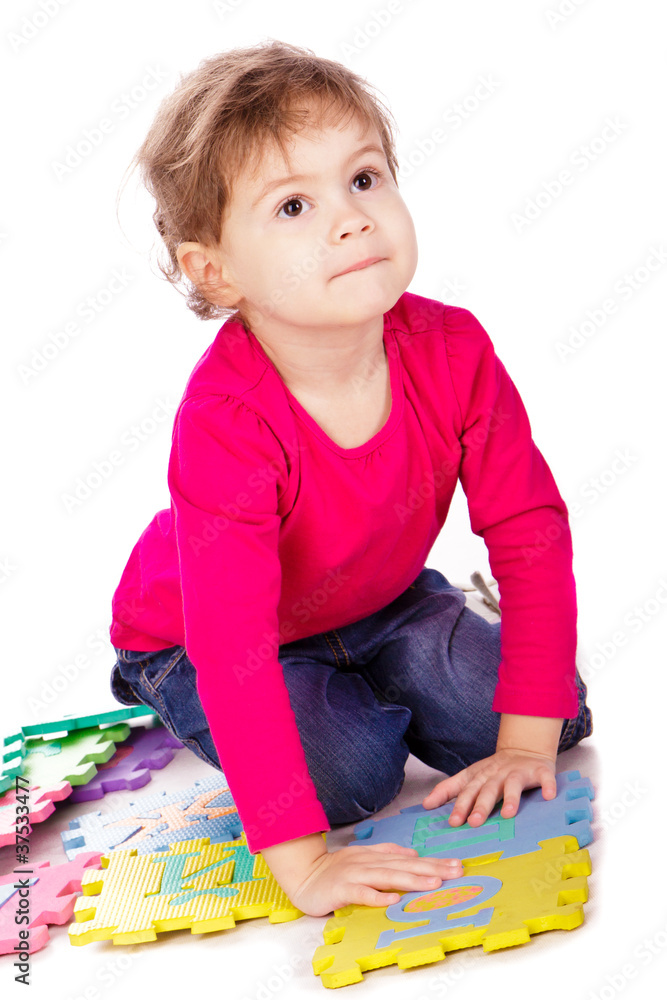 Little cute girl solving alphabet puzzle Little cute girl solving alphabet puzzle