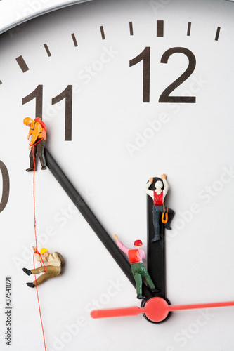 Mountaineers Scaling The Hands Of A Clock photo