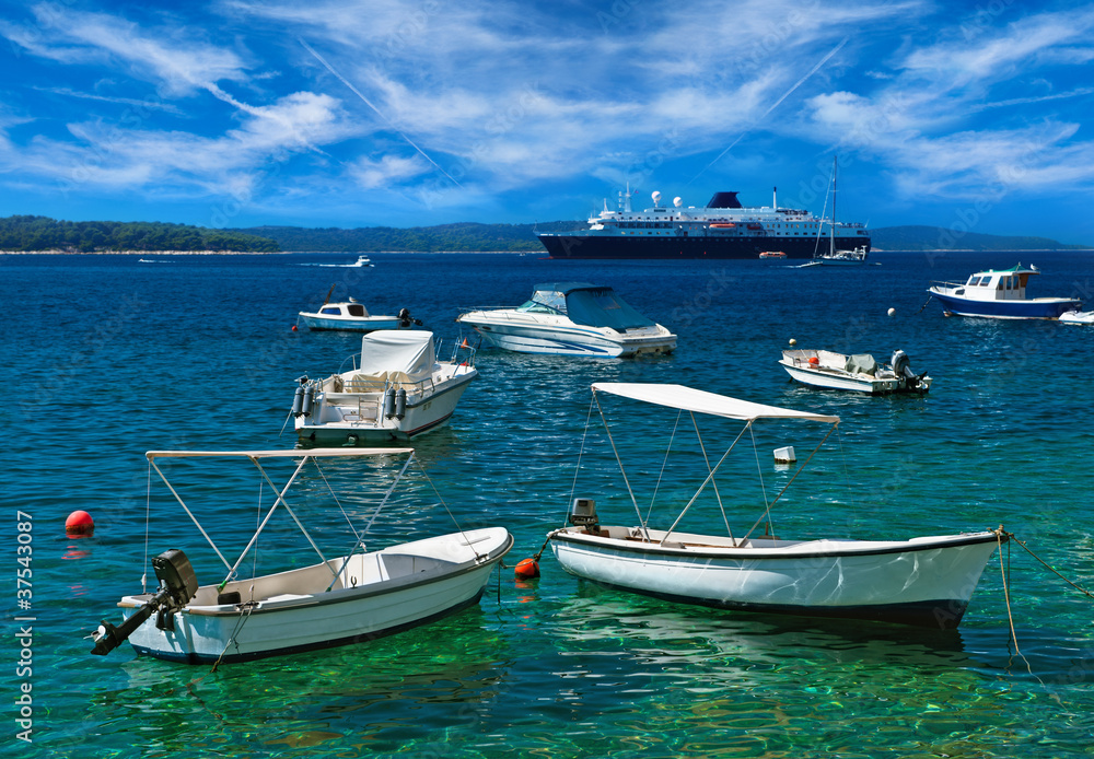 Boats at Adriatic harbor with turquoise water. Hvar, Croatia