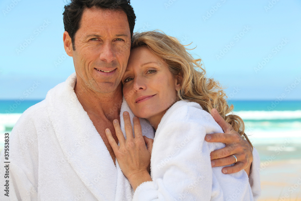 Obraz premium mid aged couple wearing a bathrobe near the sea