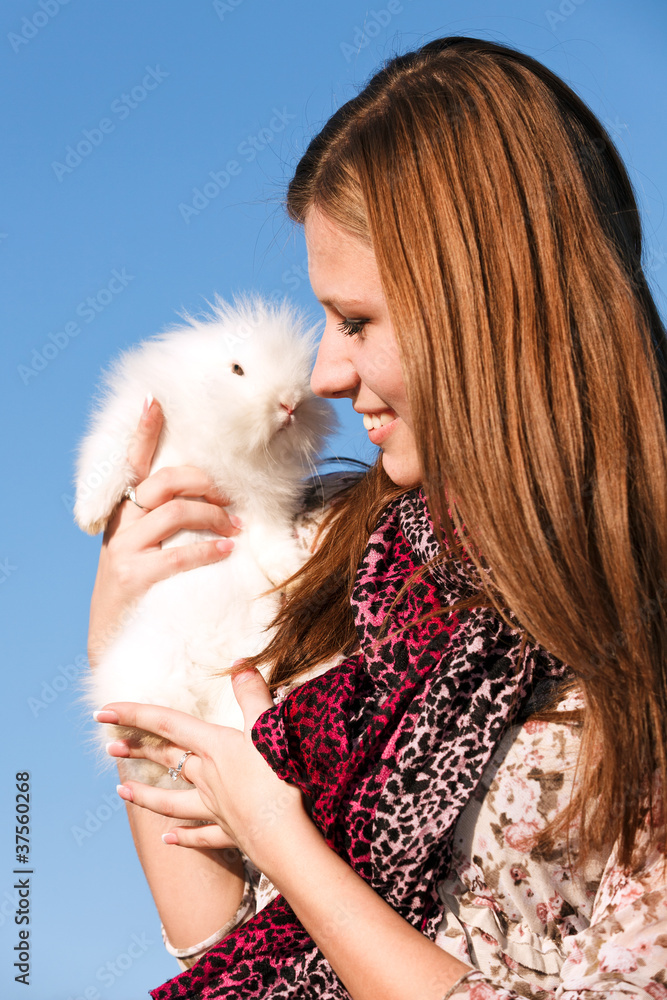 Young girl holding a white little rabbit
