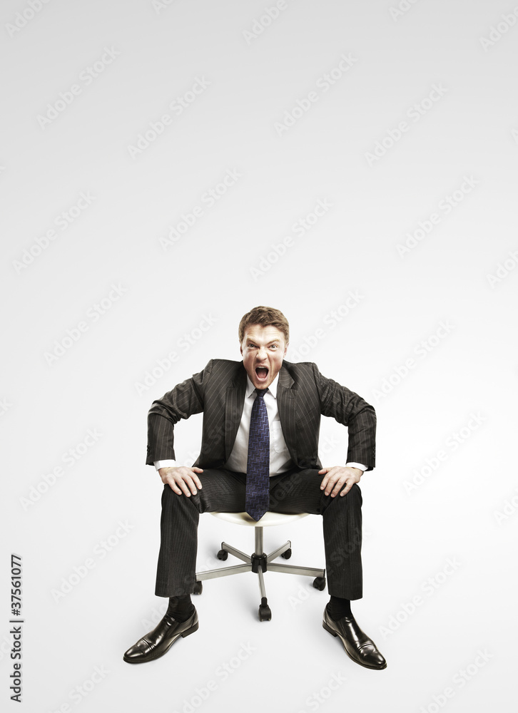 Young businessman shouting and sitting on a chair. Young businessman shouting and sitting on a chair.