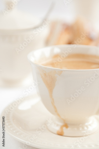 Coffee in white cup with spilled drop