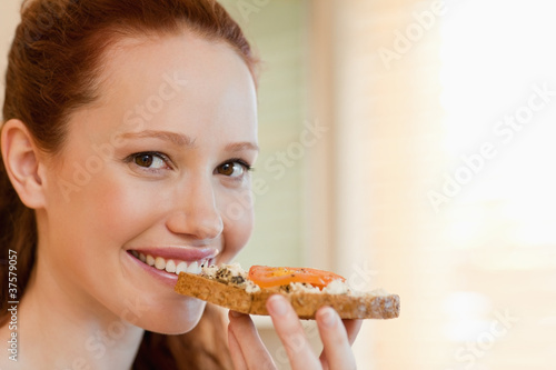 Cheerful woman with slice of bread