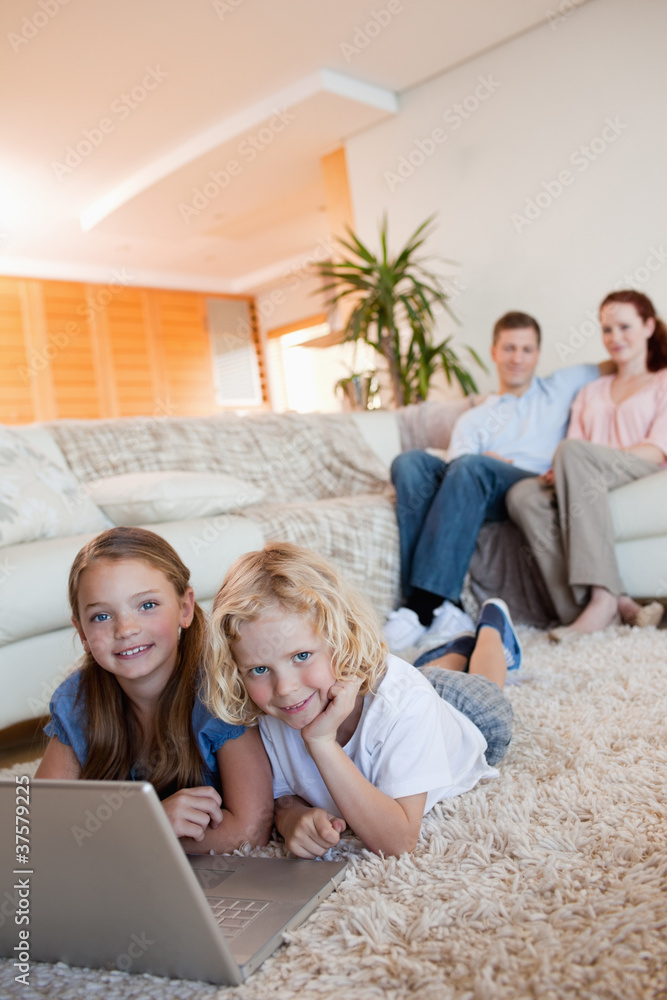 Children on the floor using laptop Children on the floor using laptop