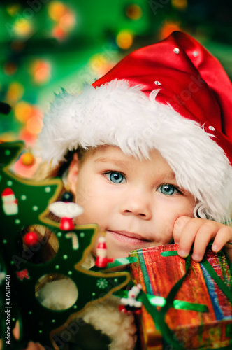 Happy small girl in santa hat with lot of gift have a christmas