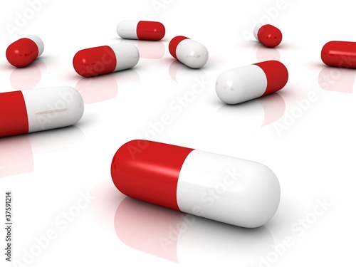 Red pharmaceutical capsules pills on white surface