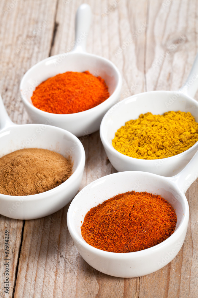 Assorted spicy powders in white bowls