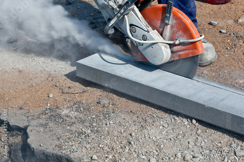 Construction cutting works with petrol driven angle grinder photo