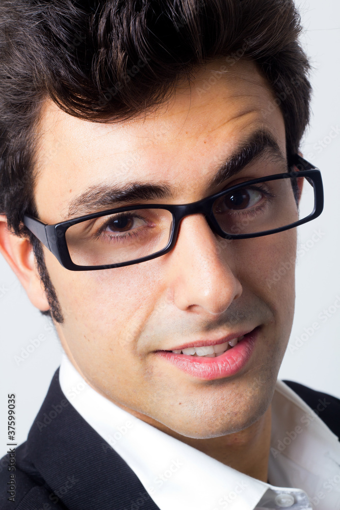 portrait of attractive young business man with reading glasses