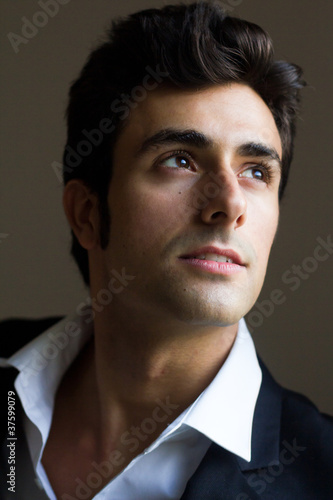 Portrait of attractive young man looking out the window