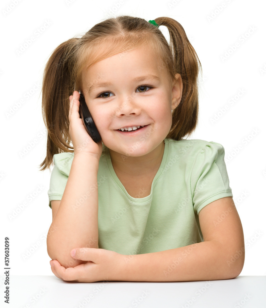 Cute little girl is talking on cell phone Cute little girl is talking on cell phone