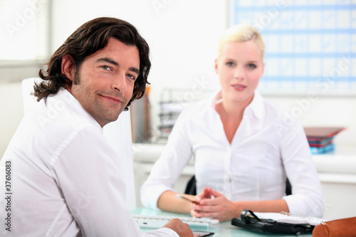 Colleagues chatting at a desk