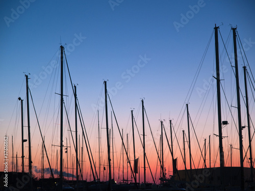 Masts of sail boats in sunset