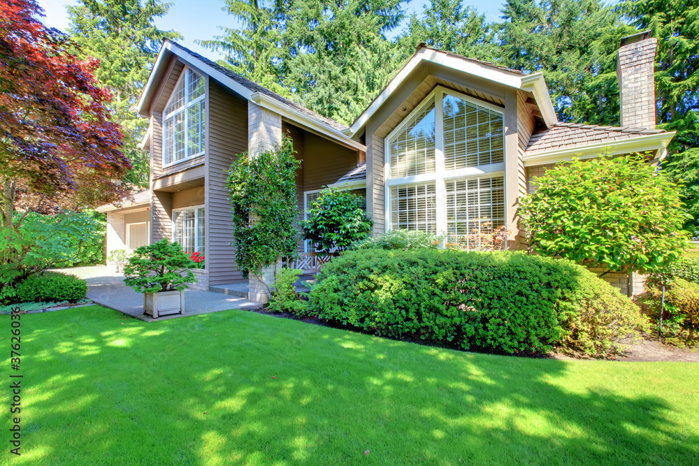 Beautiful green front garden with brown house. Beautiful green front garden with brown house.