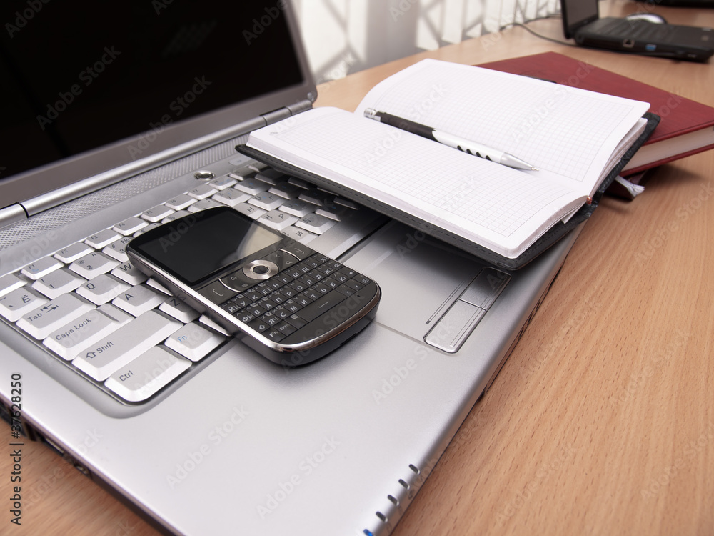 Business. Phone and notepad on laptop. Business. Phone and notepad on laptop.