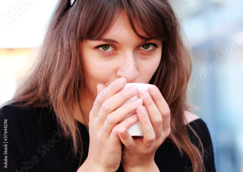young girl with a cup of coffee. Focus on the eyes.
