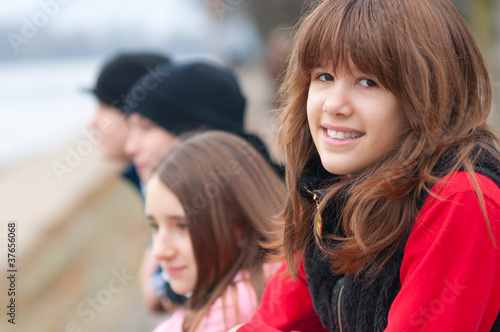Pretty smiling girl outdoor with friends in the background
