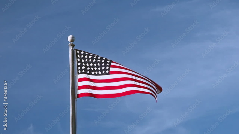USA flag flying on the wind on blue sky background USA flag flying on the wind on blue sky background