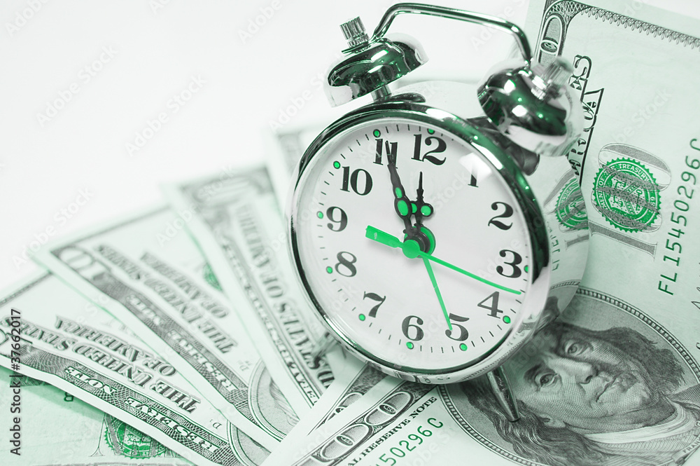 alarm clock covered pile of money . Time is money concept alarm clock covered pile of money . Time is money concept