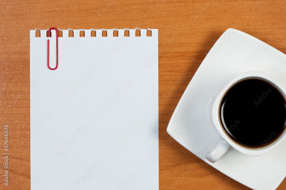 Torn sheet of paper and cup coffee on table. Torn sheet of paper and cup coffee on table.