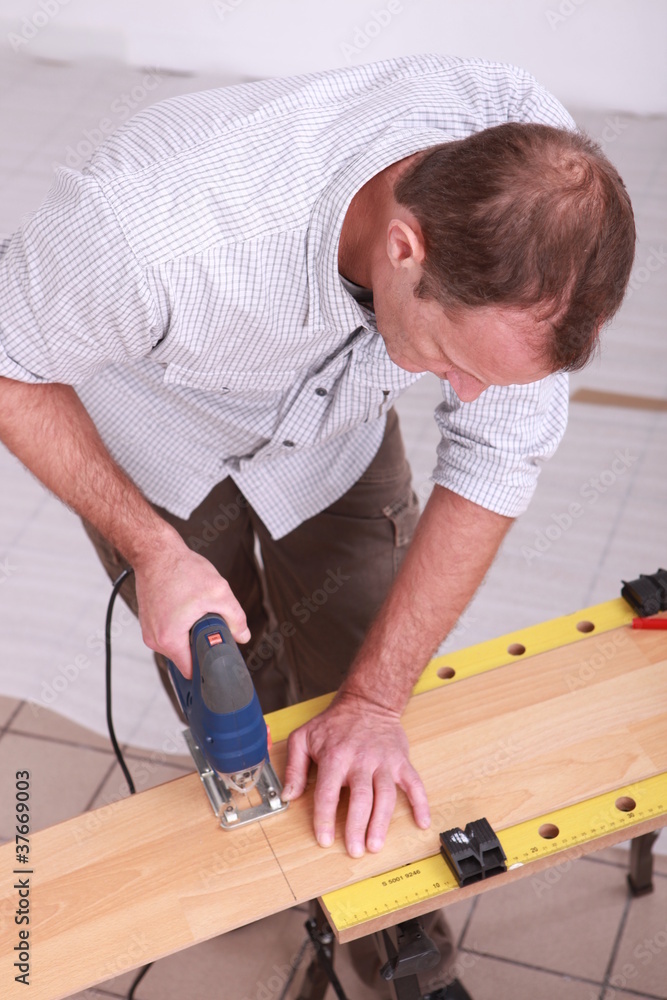 Man cutting wood with a jigsaw Man cutting wood with a jigsaw