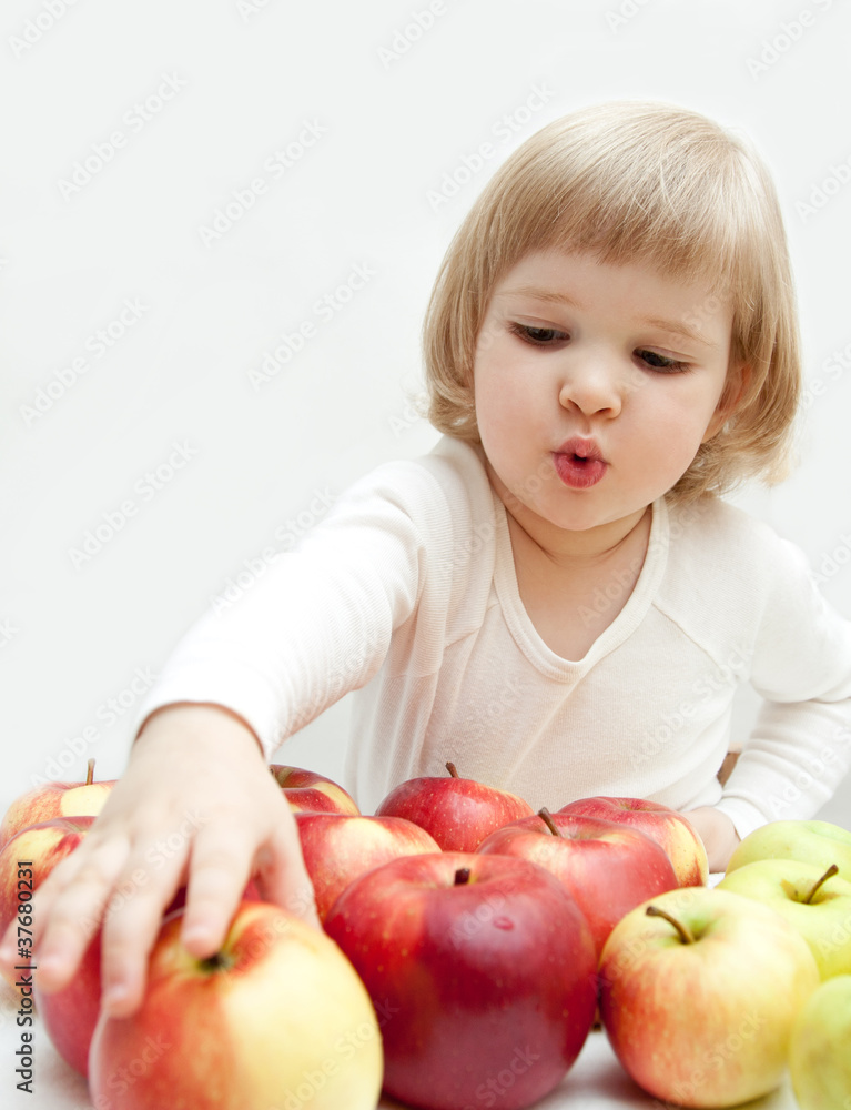 The baby girl is selecting a red apple The baby girl is selecting a red apple