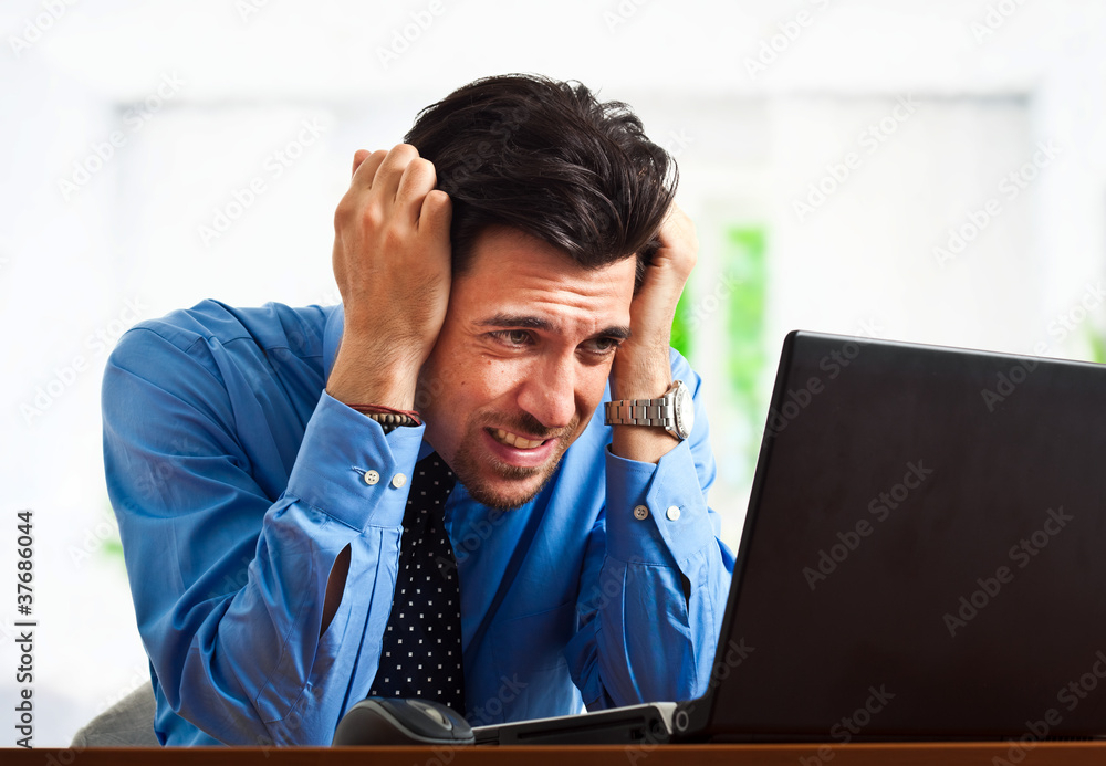 Stressed businessman looking at computer Stressed businessman looking at computer