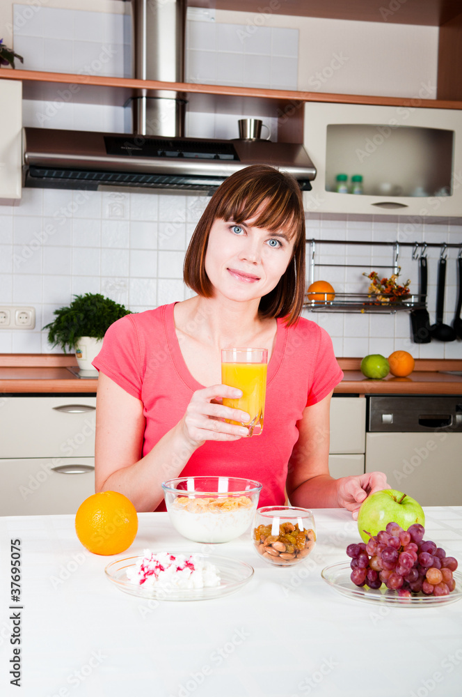 Young woman drinking orange juice at home