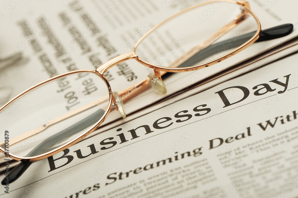 Eyeglasses lie on the newspaper with title Business day Eyeglasses lie on the newspaper with title Business day