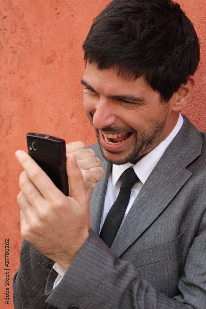Businessman holds his smartphone and celebrates Businessman holds his smartphone and celebrates