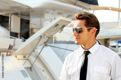 Wallpaper Mural Handsome man, a serious captain in a white shirt near the yacht, Torontodigital.ca